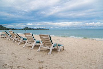 Rows of sun bed at sand beach for relaxing with tropical beach and sea
