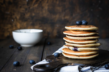ricotta pancakes with blueberries on a dark wooden background