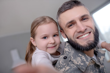 Dad military and little daughter are happy together.