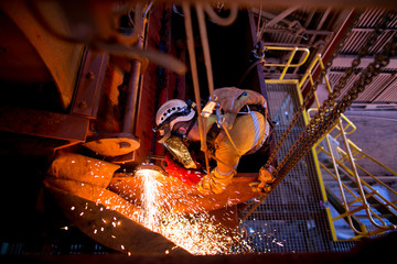 Tope view pic male rope access welder wearing full body safety equipment harness abseiling working...