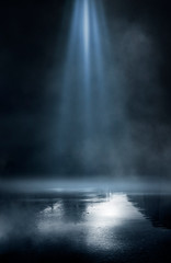 Wet asphalt, reflection of neon lights, a searchlight, smoke. Abstract light in a dark empty street with smoke, smog. Dark background scene of empty street, night view, night city.