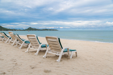 Rows of sun bed at sand beach for relaxing with tropical beach and sea