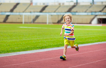 Fototapeta premium Child running in stadium. Kids run. Healthy sport.