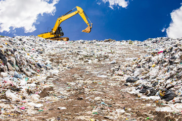 garbage dump pile in trash dump or landfill,backhoe is dumping the gabage from municipal,garbage...