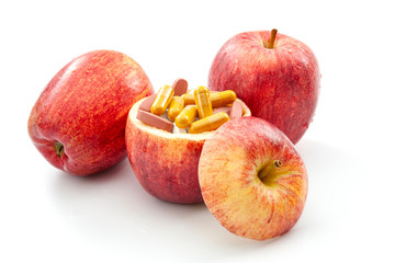 Nourishing diet and replenish vitamins, minerals and supplements through healthy organic food concept with apples full of vitamin and mineral pills isolated on white background