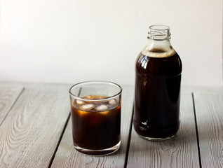  iced cold brew coffee in a bottle and in a glass. CBD concept. Modern fashionable drinks to go.