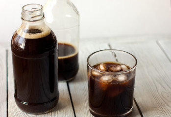  iced cold brew coffee in a bottle and in a glass. CBD concept. Modern fashionable drinks to go.