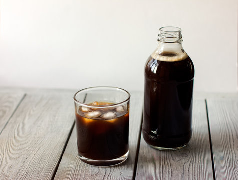  iced cold brew coffee in a bottle and in a glass. CBD concept. Modern fashionable drinks to go.