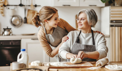 happy family grandmother  old mother mother-in-law and daughter-in-law daughter cook in kitchen,...
