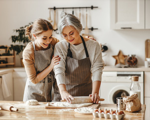 happy family grandmother  old mother mother-in-law and daughter-in-law daughter cook in kitchen,...