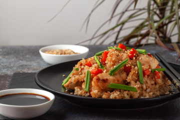 Tori chahan fried Japanese rice with vegetables and chicken in soy sauce in a black plate on a serving board © Nataliia Yudina