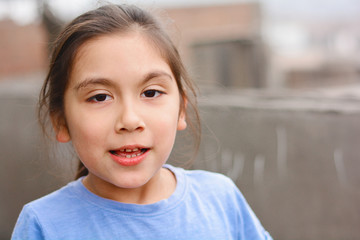 Little latin girl talking outside.
