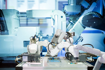 Industrial automation robotic teamwork working with circuit board on smart factory, on machine blue...