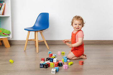 Smiling baby playing with alphabet blocks