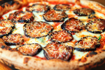 Freshly baked pizza with cheese, sauce and eggplants close up