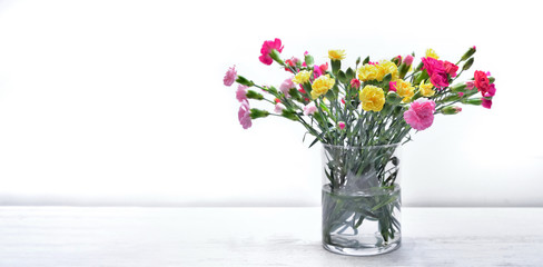bouquet of fresh flowers carnation colorful in a glass jar on a table