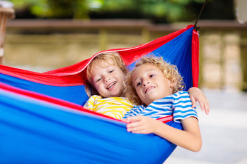 Fototapeta na wymiar Boy in hammock. Kids play in summer garden.