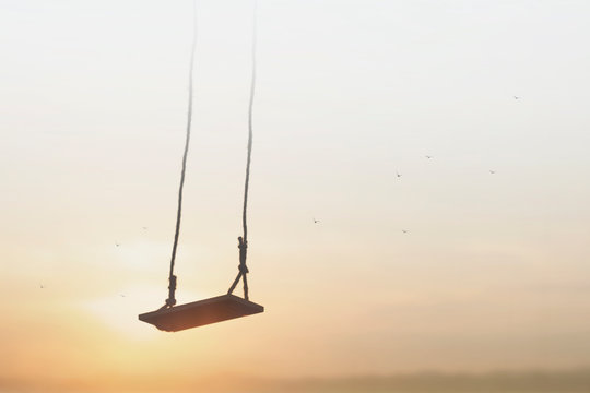 lonely swing surreally hanging from the sky