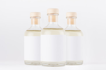 Group glass bottles for cosmetic, perfume, alcohol drink with  white label, cork, yellow liquid on white background, mock up for  design.