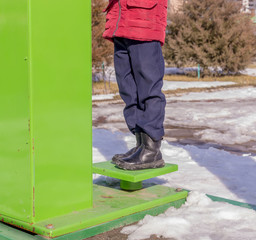 Boy on a public street simulator in winter. Children sports