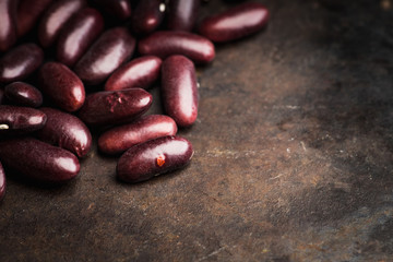 Purple beans on the rustic background. Selective focus. Shallow depth of field.