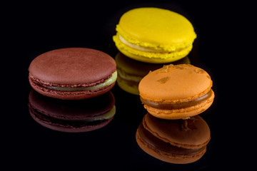 French sweet dessert. Colorful delicious macaron cakes. Black background.