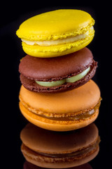 Multicolored delicious  cakes macarons. Black background.