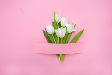 Creative layout with white tulips on a pink background. holiday concept. Flat lay, top view. 