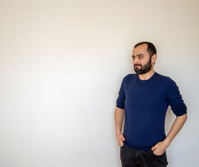 Portrait of Young Turkish man who keeps hands in pockets, raises eyebrows in bewilderment, shrugs shoulders, has to make difficult life choice, looks confused.
