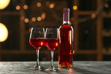 Glasses and bottle of delicious wine on table in bar