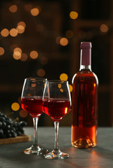 Glasses and bottle of delicious wine on table in bar