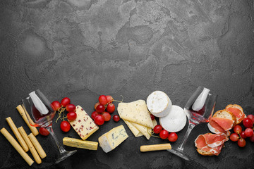 Delicious wine with snacks on dark background