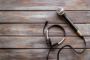 Television concept. Microphone and headset on dark wooden background top-down copy space