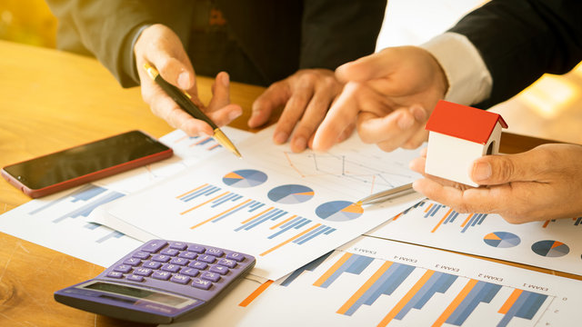 2 businessmen meet to work with project.discussion And new data analysis, valuation charts and charts with calculators and home and telephone designs.