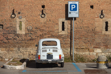 Small Italian car against the ancient brick wall.