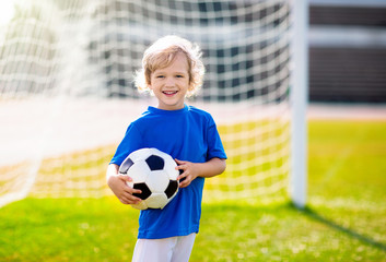 Kids play football. Child at soccer field.