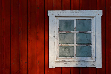 A small old window with frosty glass in morning sun