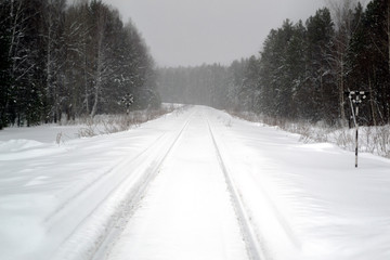 Obraz premium Snow-covered railway in the middle of a winter forest. Blurred photo bokeh 