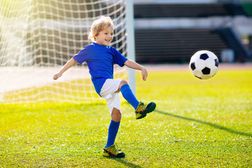 Kids play football. Child at soccer field.