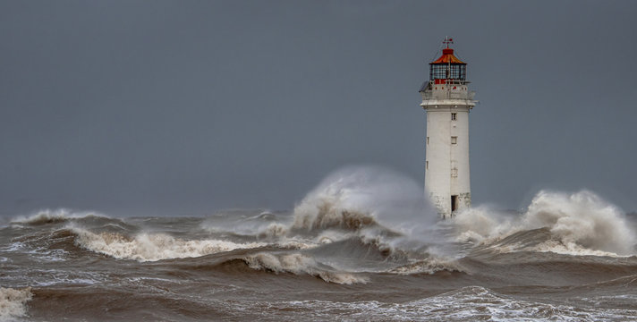 New Brighton Lighthouse at Perch Rock on the opposite side of the River Mersey to Liverpool. Taken during a storm with rough sea and high waves