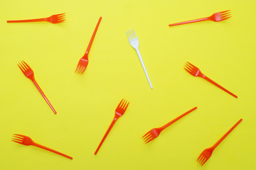 Plastic forks on yellow background.