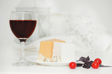 Glass of red wine and cheese on a plate