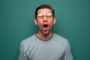 Portrait of shocked surprised young man in glasses