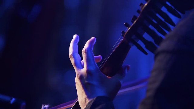 Close up for a persons hand playing violin at a concert