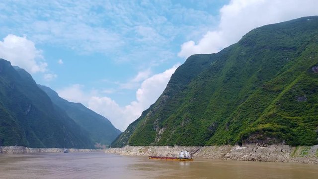 Cargo ship transporting goods, products and vehicles sailing through the gorge on the magnificent Yangtze River, China