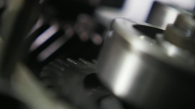 Sparkling ball-bearing and wide cogwheel rolling fast in a modern car transmission