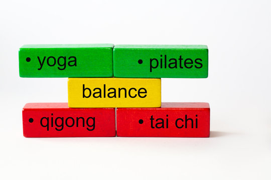 colored toy blocks with the words yoga, pilates, qigong, tai chi, and the word balance in the middle