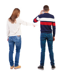 Obraz premium Back view of couple in sweater with mobile phone.