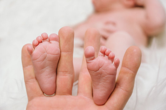 Feet of a newborn baby in the hands of parents. Happy family moment and concept.