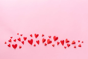 Valentine's Day. Beautiful red paper hearts isolated on pink.
